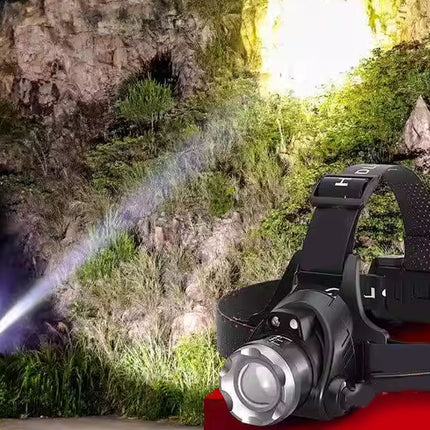 Headlamp illuminating a natural outdoor setting with rocks and greenery.