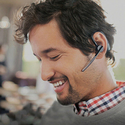 Man wearing a wireless earbud with a blurred outdoor background