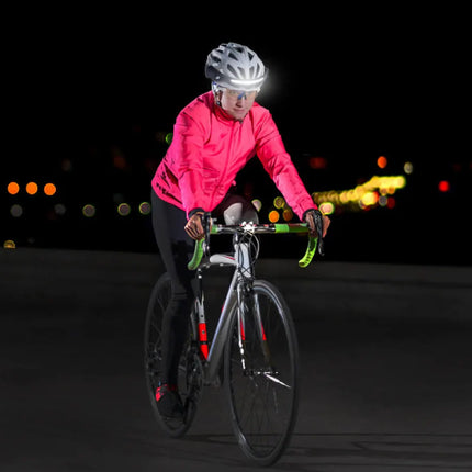 Person riding a bicycle at night with a bright light on a dark background
