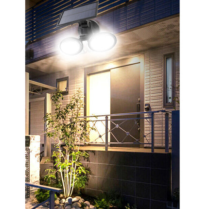 Outdoor light fixture on a building exterior with plants and railing.