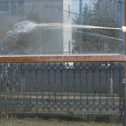 Person cleaning a glass door with a high-pressure washer.