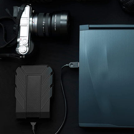 Camera with external hard drive and power adapter on a dark surface