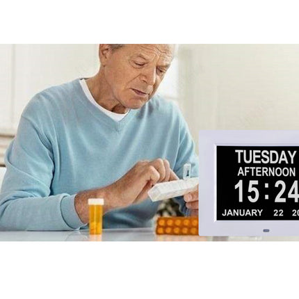 Man with a digital clock displaying date and time, next to pill bottle and containers.