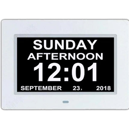 A digital alarm clock with a white rectangular frame and a black display screen showing the time 12:01 on Sunday afternoon, September 23, 2018.