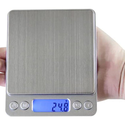 Digital pocket scale held in a hand with a white background