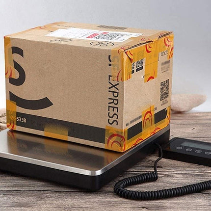 Cardboard box on a digital scale with an Amazon label, on a wooden surface.