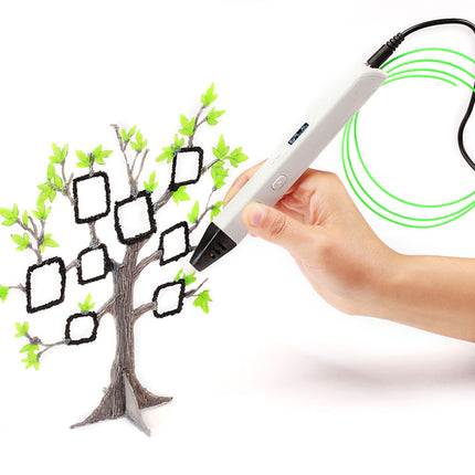 A 3D pen drawing tablet held by a person's hand, creating a tree with green leaves and black outlined photo frames on a white background.
