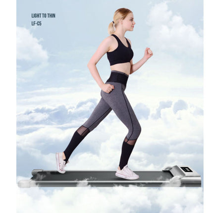 Woman running on a treadmill with a cloudy sky background