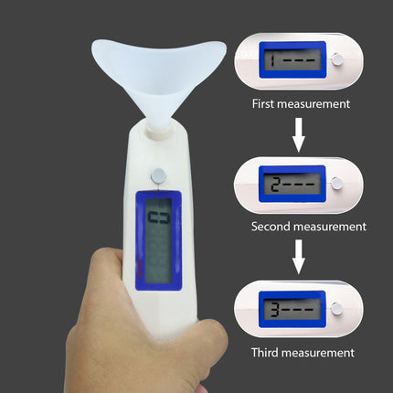 Digital thermometer held by a hand with measurements displayed on small digital screens.