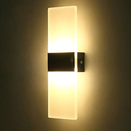 Wall-mounted light fixture casting a warm glow on a dark wall