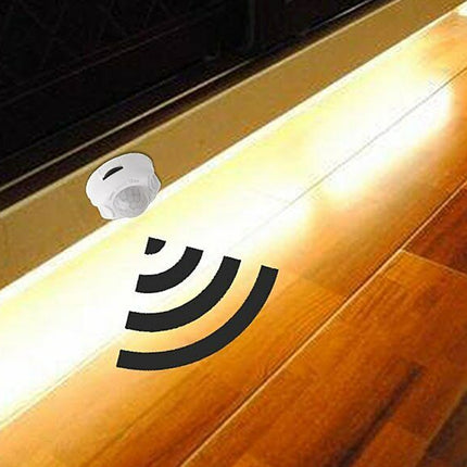 Intrusion alarm system on a wooden floor with a light source.