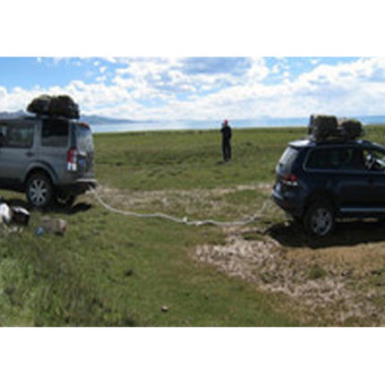 Two cars with roof racks in a grassy field with a lake in the background.