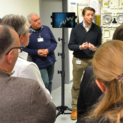 Person giving a presentation to a group of people in an indoor setting.
