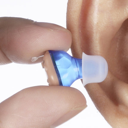 Close-up of a blue and white hearing aid being inserted into an ear.