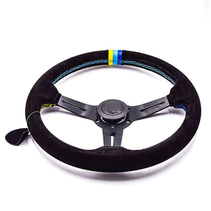 A black suede-wrapped racing steering wheel with a black three-spoke carbon fiber center, featuring a blue and yellow accent stripe on the upper rim.