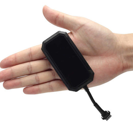 A small black electronic device with a flat front face and attached cable, shown resting on an open hand against a plain white background.