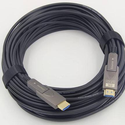 A coiled black HDMI cable secured with a black elastic band, featuring gold-plated connectors with blue USB 3.0 accents, photographed on a white background.