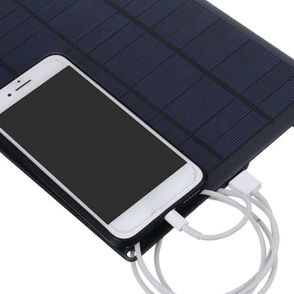 Solar panel charging a smartphone with multiple cables on a white background