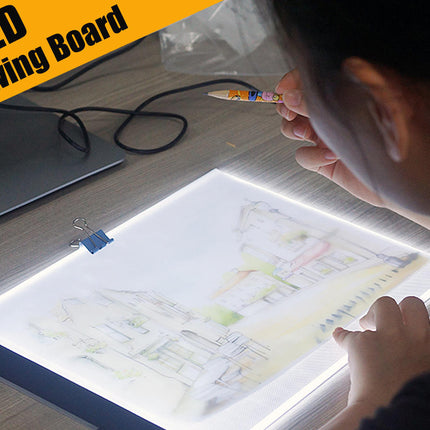 Person using an LED drawing board with a light-up surface