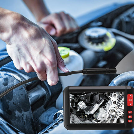 A handheld automotive engine inspection camera with a flexible black probe inserted into an engine bay, with a monitor screen overlay showing the internal engine details.