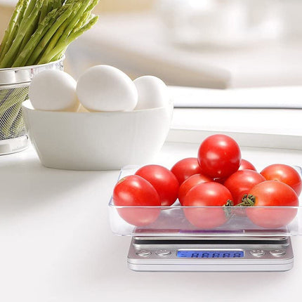Tomatoes on a digital kitchen scale with eggs and asparagus in the background