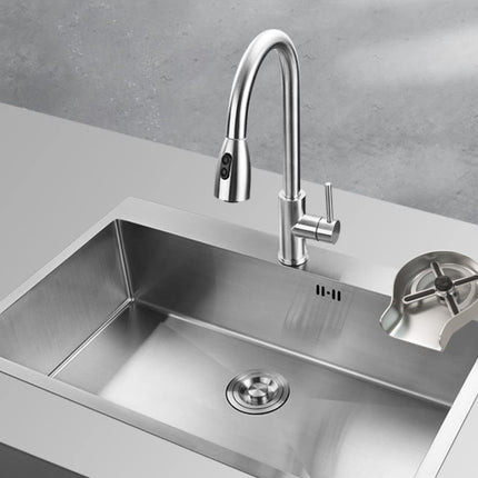 A modern stainless steel kitchen sink with a high-arc chrome faucet and a matching drain cover, set into a light gray countertop against a textured gray wall.
