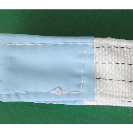 Two pieces of fabric, one blue and one white with black lines, on a green background.