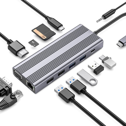 A silver aluminum multi-port USB-C hub with a ribbed metal body, shown with various black and silver cables, a USB flash drive, and a microSD card on a clean white background.