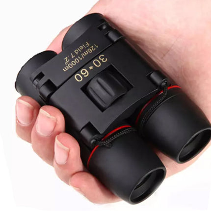 Black binoculars held in a hand with a white background