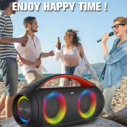 Group of people enjoying time on a beach with a colorful Bluetooth speaker in the foreground.