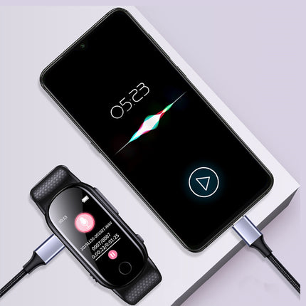 A black smartwatch with a band is shown alongside a smartphone on a white display stand, both connected to silver USB-C cables against a light lavender background.
