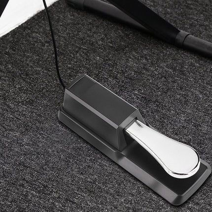 Sustain pedal for musical instruments on a dark surface