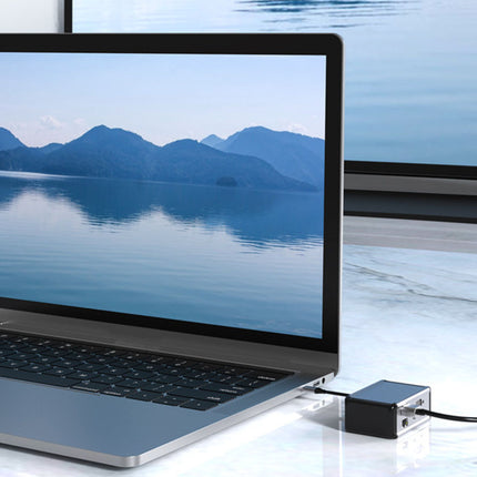Laptop with screen displaying a mountain landscape on a reflective surface