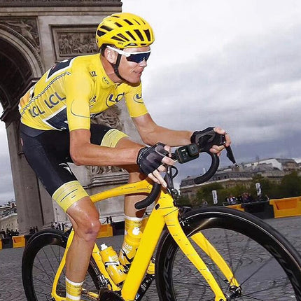 Cyclist in a yellow jersey riding a yellow bicycle in an urban setting.