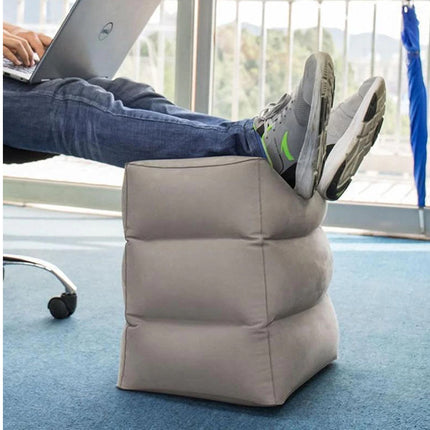Person using a footrest in an office setting with a laptop on their lap.