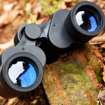 Binoculars on a wooden surface with a natural background