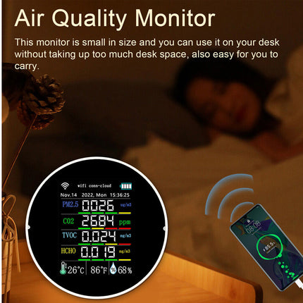 Air quality monitor displayed on a desk with smartphone showing app interface.