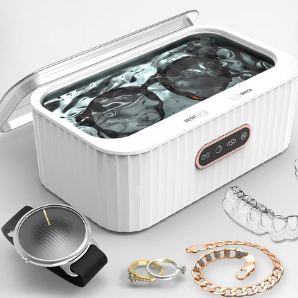 Jewelry cleaner with various jewelry items on a light gray background