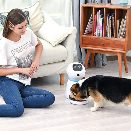 Woman sitting on the floor with a dog and a robot in a living room setting.