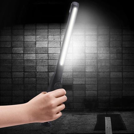 Hand holding a flashlight against a dark tiled wall