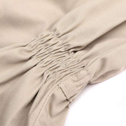 Close-up of beige fabric with visible stitching on a white background