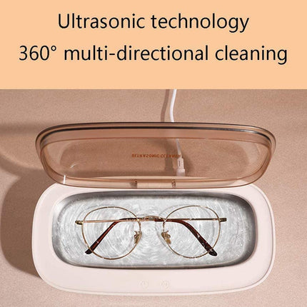 An open ultrasonic glasses cleaner with a translucent brown lid and a white base, shown with a pair of round metal-framed glasses inside. Text at the top reads 'Ultrasonic technology 360° multi-directional cleaning'.