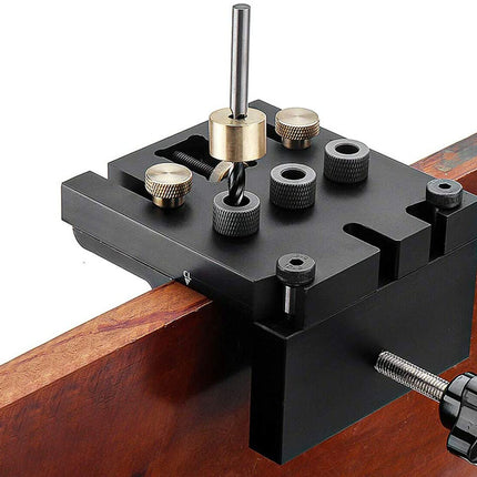 Black metal tool holder with drill bit on a wooden surface