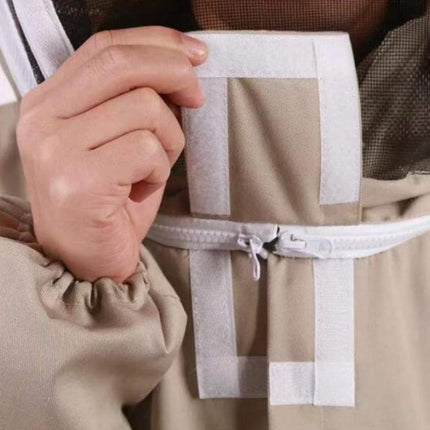 Close-up of a person holding a beige bag with a white strap.