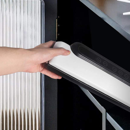 Hand using a handheld vacuum cleaner to clean a surface.