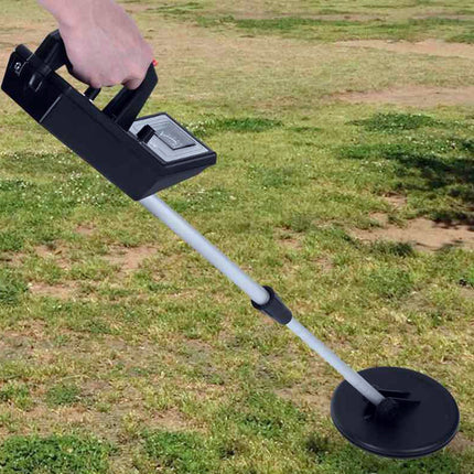 Metal detector held by a person on grass