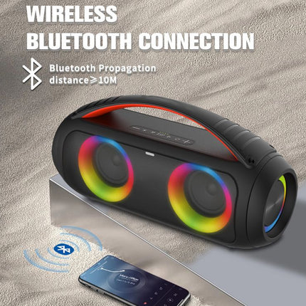 Black wireless Bluetooth speaker with colorful lights on a sandy background