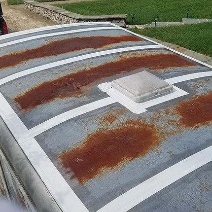 Rust on a flat roof with a white vent in the center, outdoors.