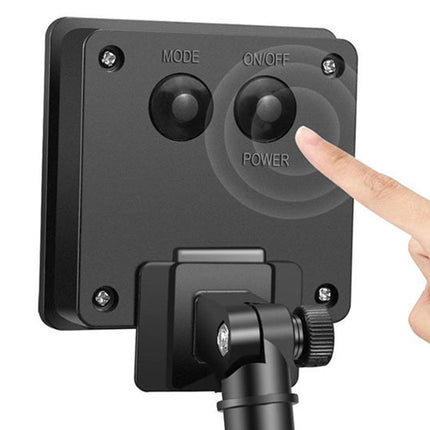 Black outdoor camera with power and mode switches, being pointed at by a hand on a white background