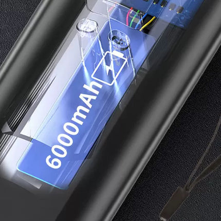 Close-up of a black rectangular electronic device with a glossy transparent cover showing a blue panel labeled '6000mAh' and a battery icon.